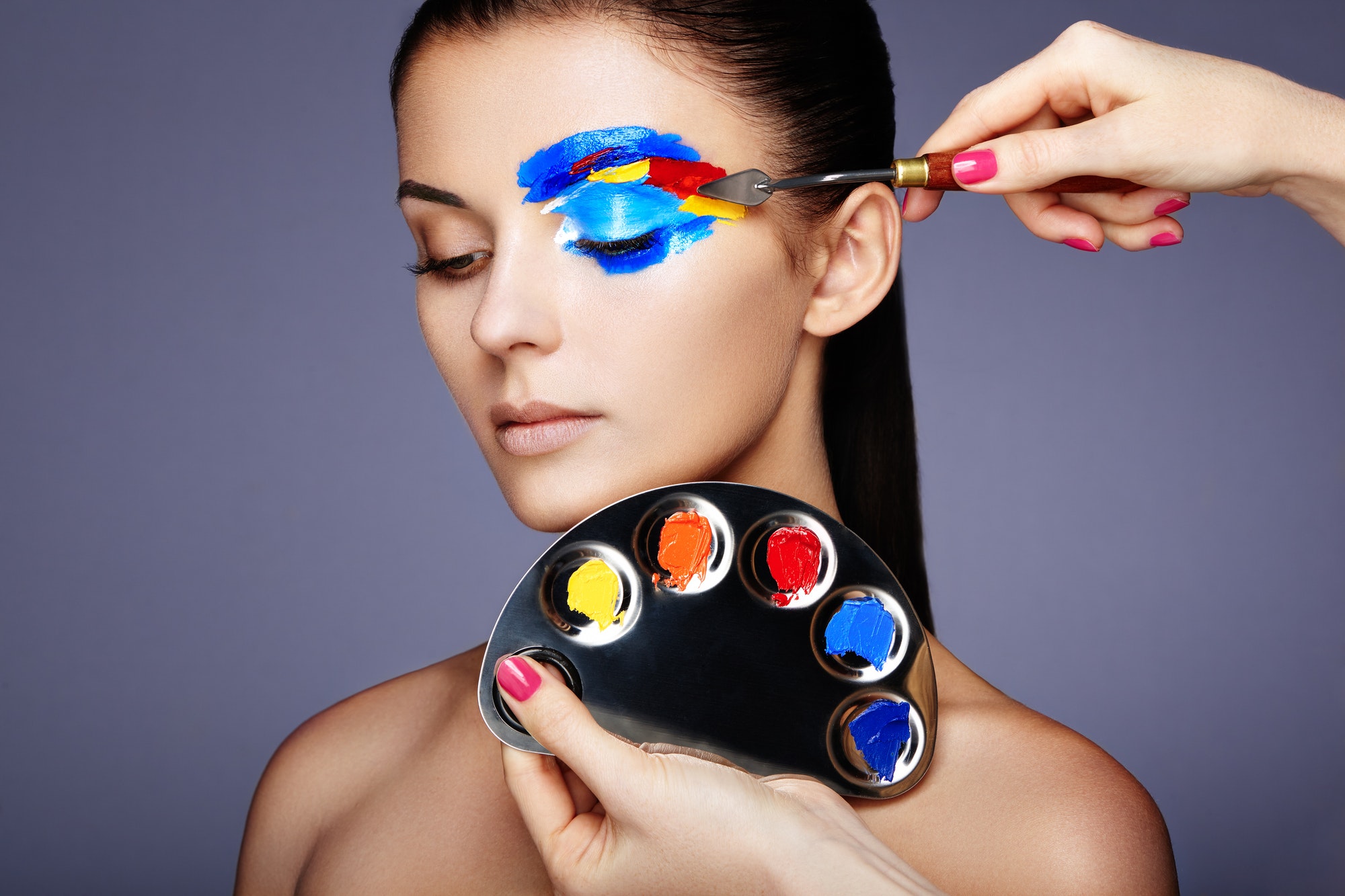 Makeup artist applies colorful makeup