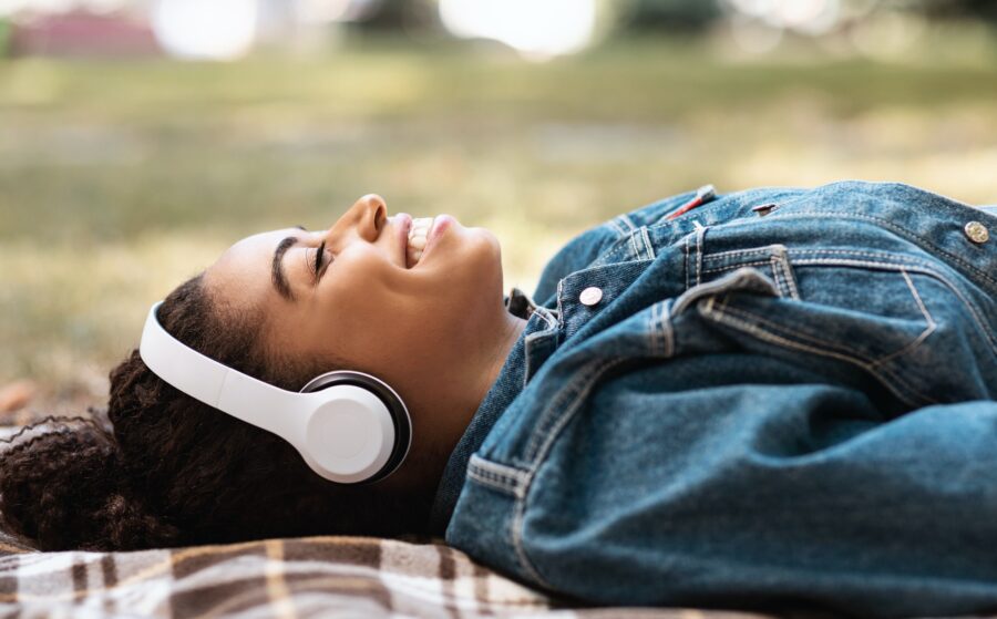 Black Lady Listening Music Lying On Plaid Relaxing In Park