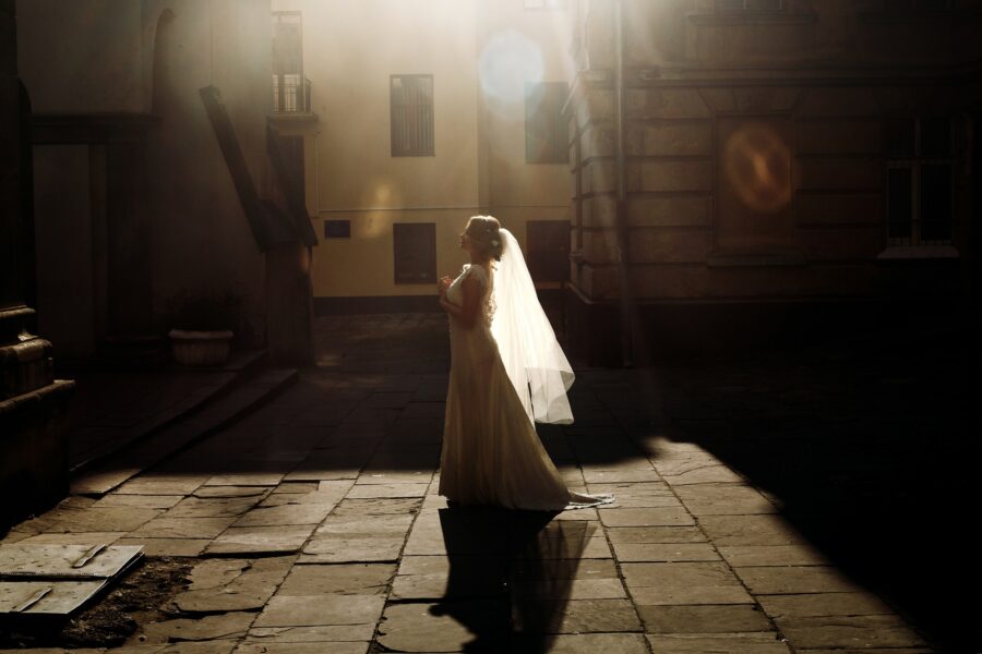 Beautiful fairytale bride in vintage white wedding dress walking down
