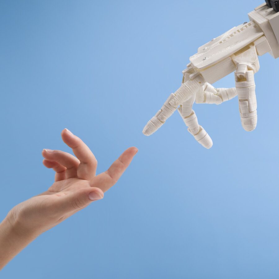 Female and robot hands reaching to each other on blue background
