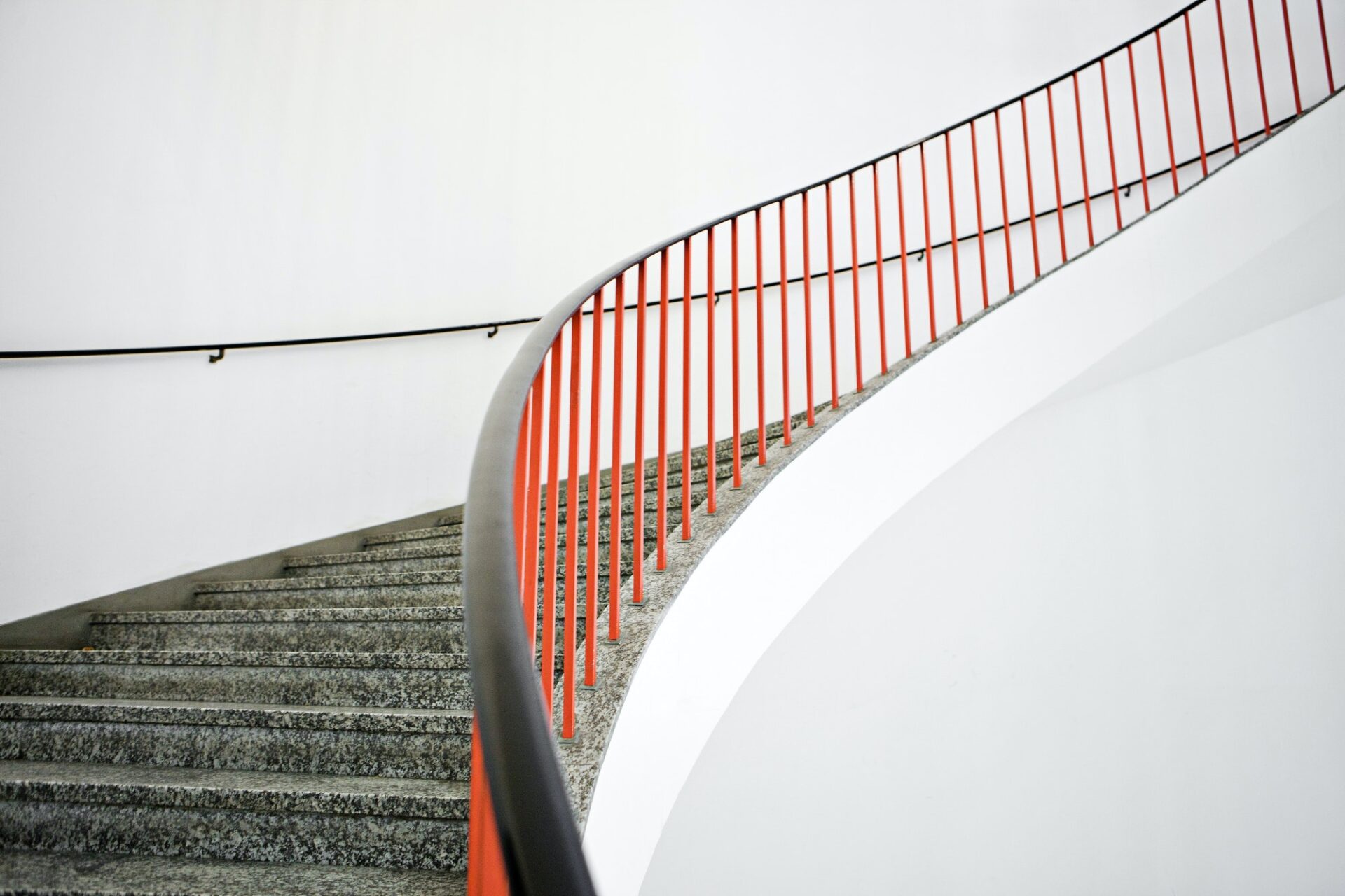 Curved stairs with red banister