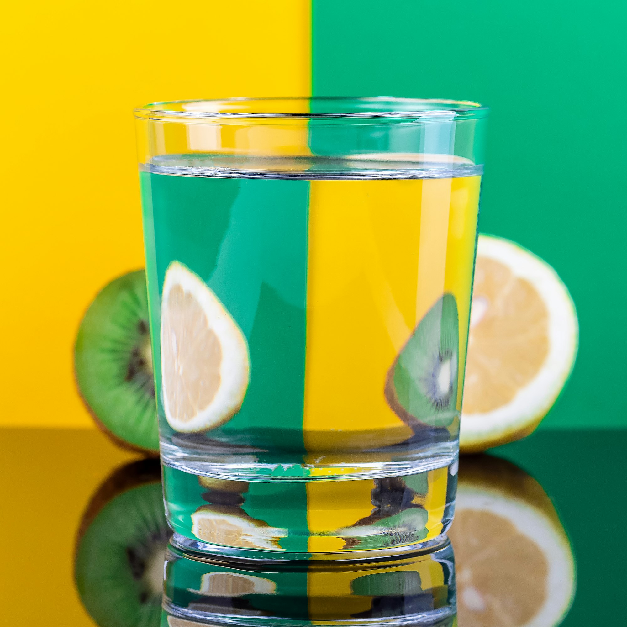 Optical illusion with kiwi and lemon distorted through glass of water