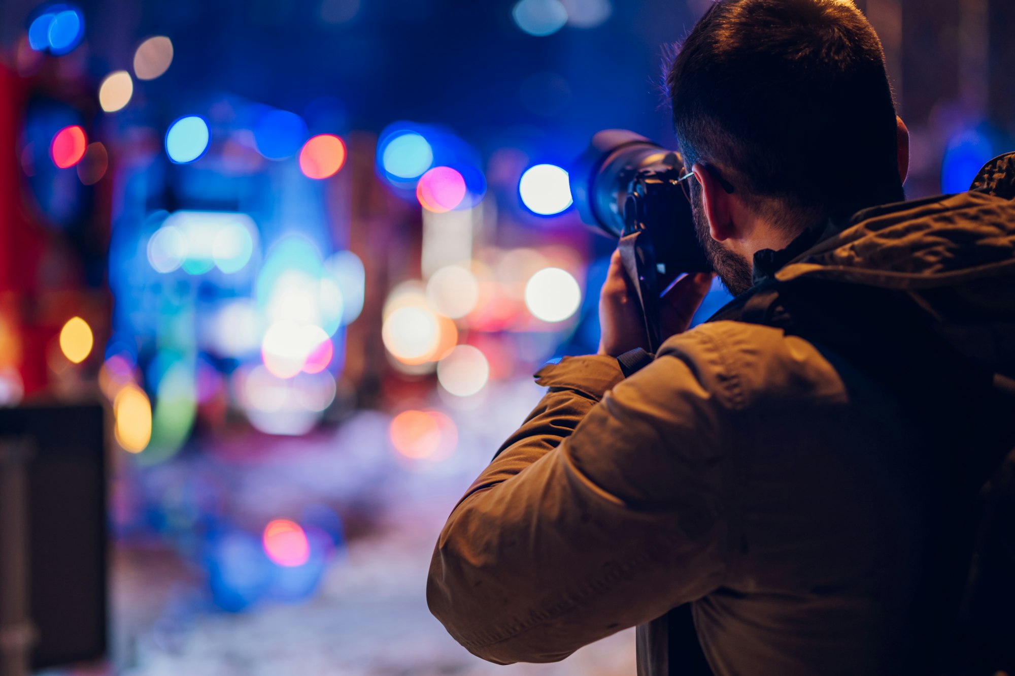 Reporter photographer shooting in the city street in the night