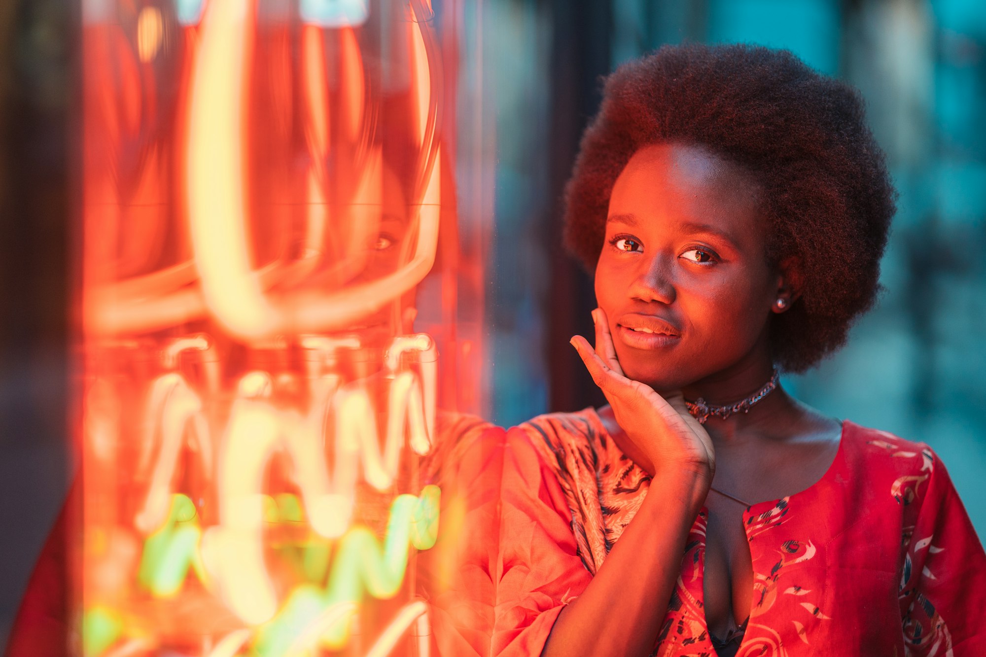 Young woman standing next to neon light