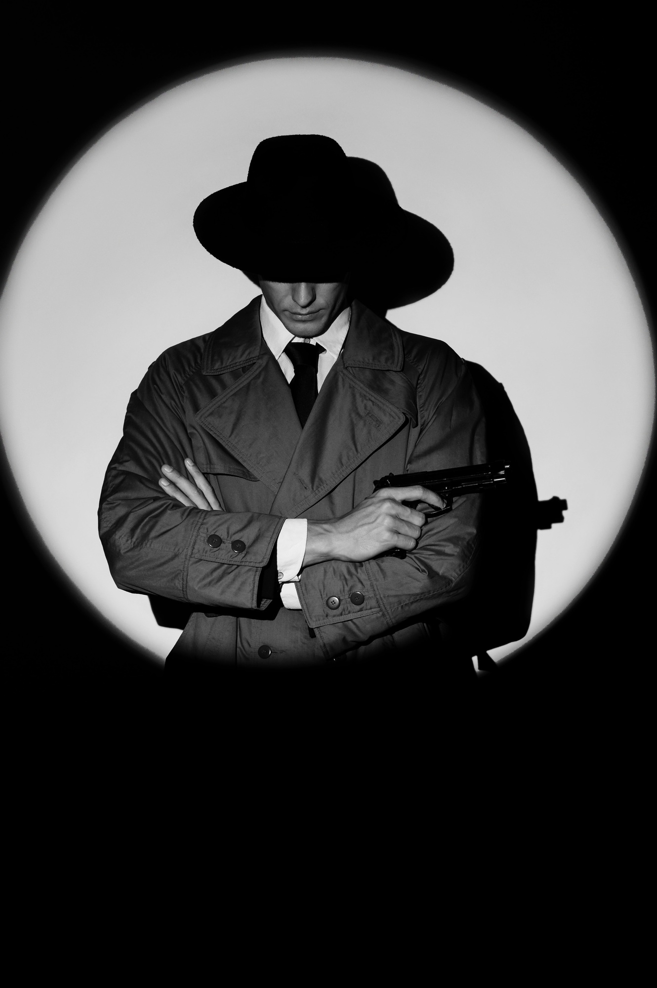 A dark silhouette of a male detective in a coat and hat with a gun in his hands in the noir style.