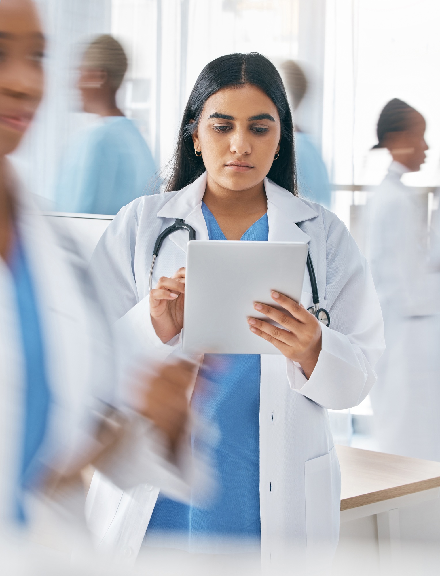 Doctor, tablet and busy hospital with internet research, online schedule and digital calendar at wo