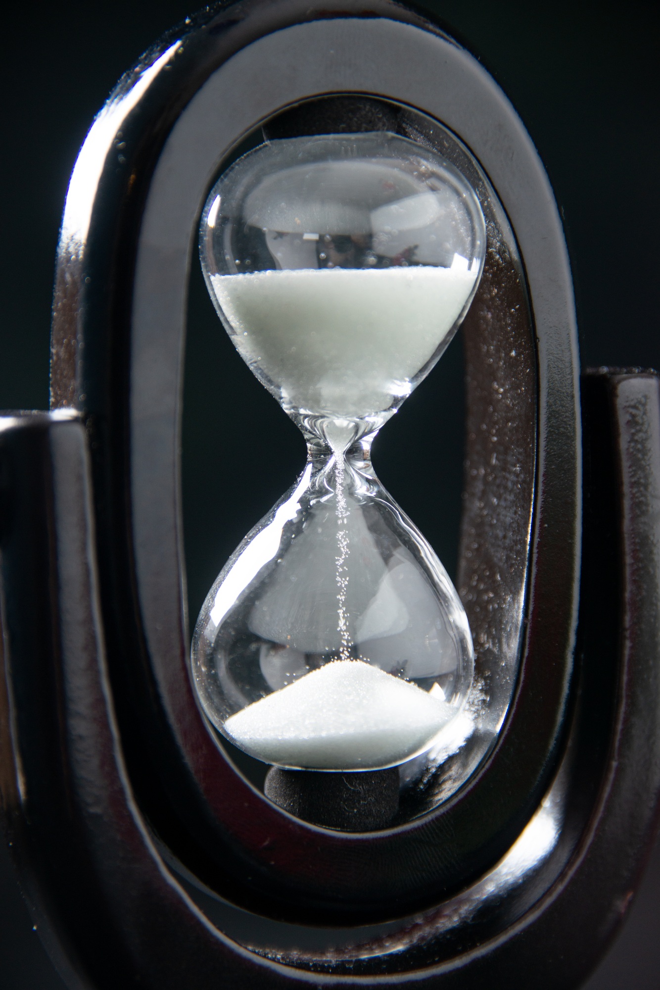 front view of black hourglass on a dark surface funeral evil israel war death time