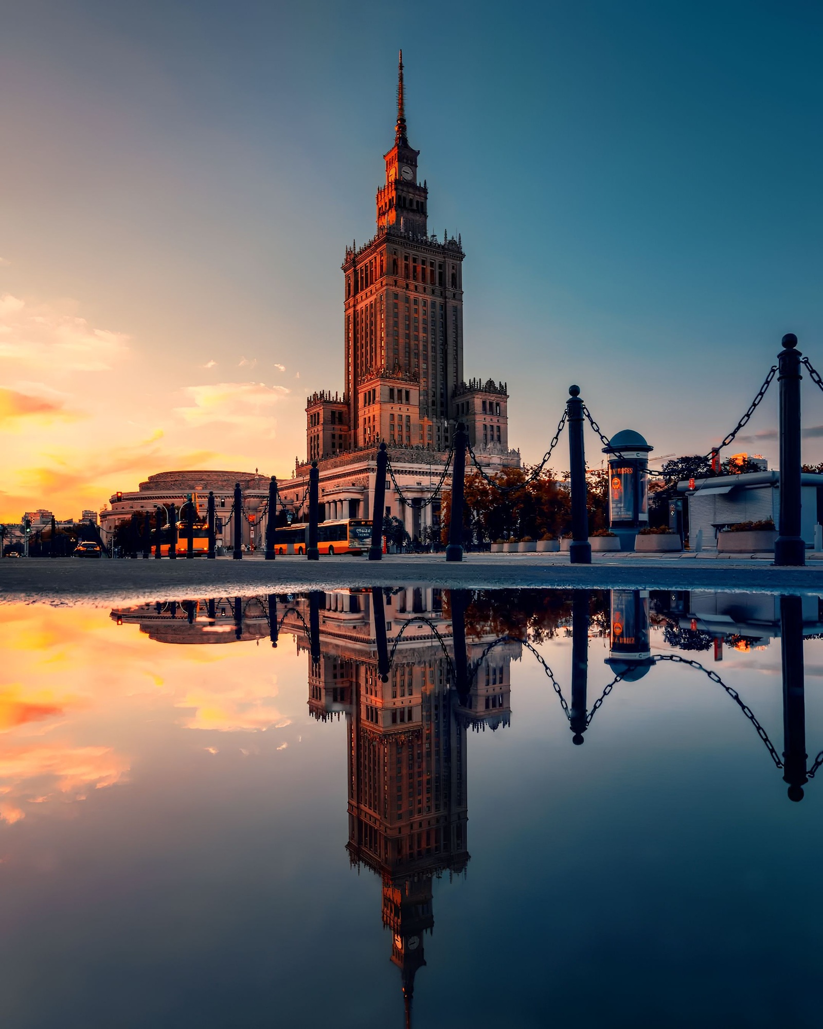 Palace of Culture and Science reflecting in the water at sunset in Warsaw, Poland.